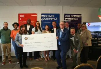 Group of people holding up large check