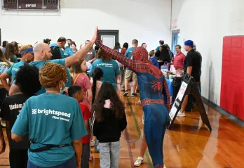 spiderman high fiving a volunteer over a child at Kernersville Bright Beginnings