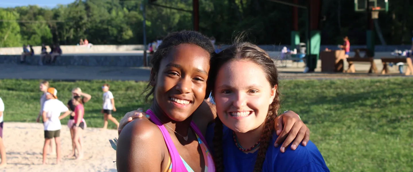 Two girls hugging in a field