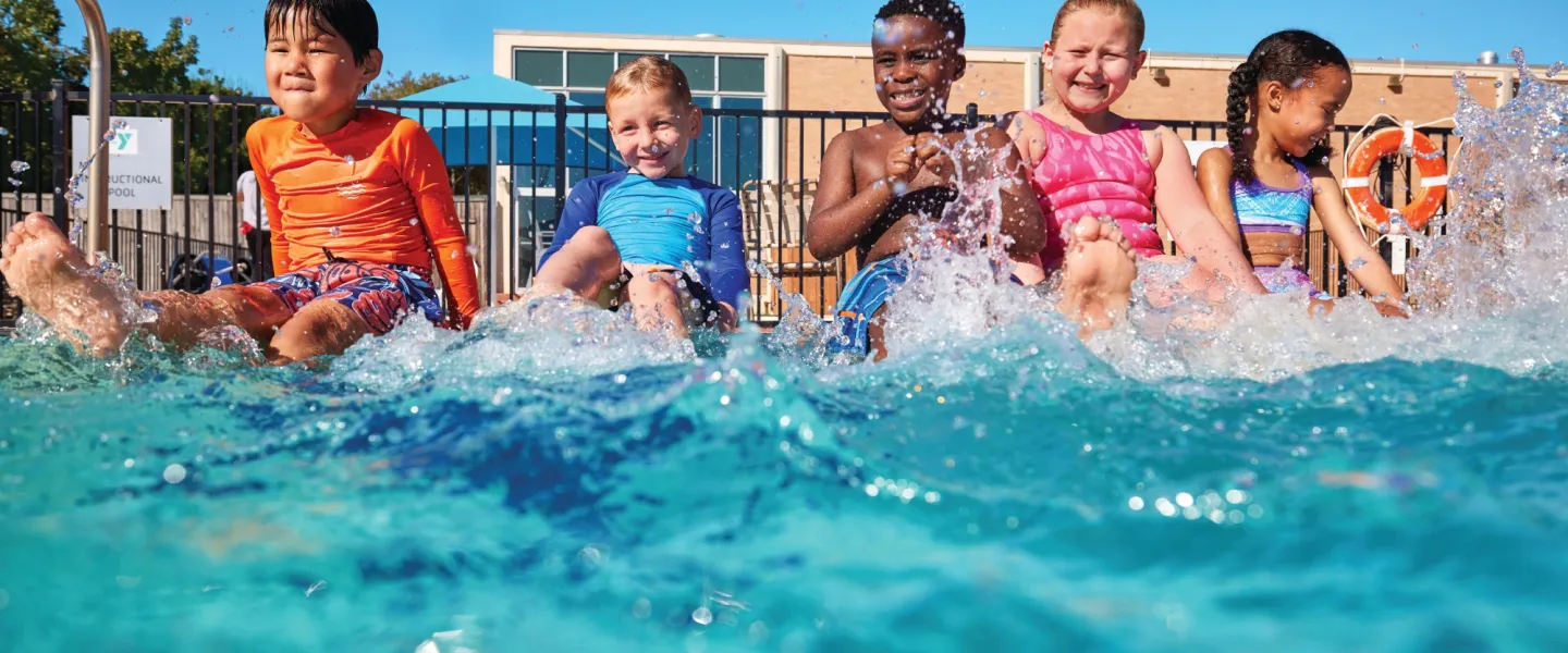 Kids on the side of the outdoor pool