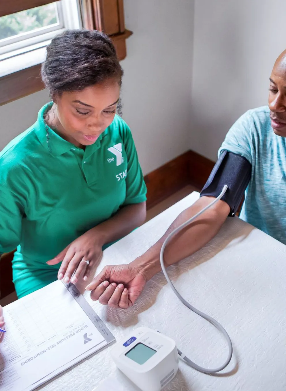 YMCA staff person taking someone's blood pressure