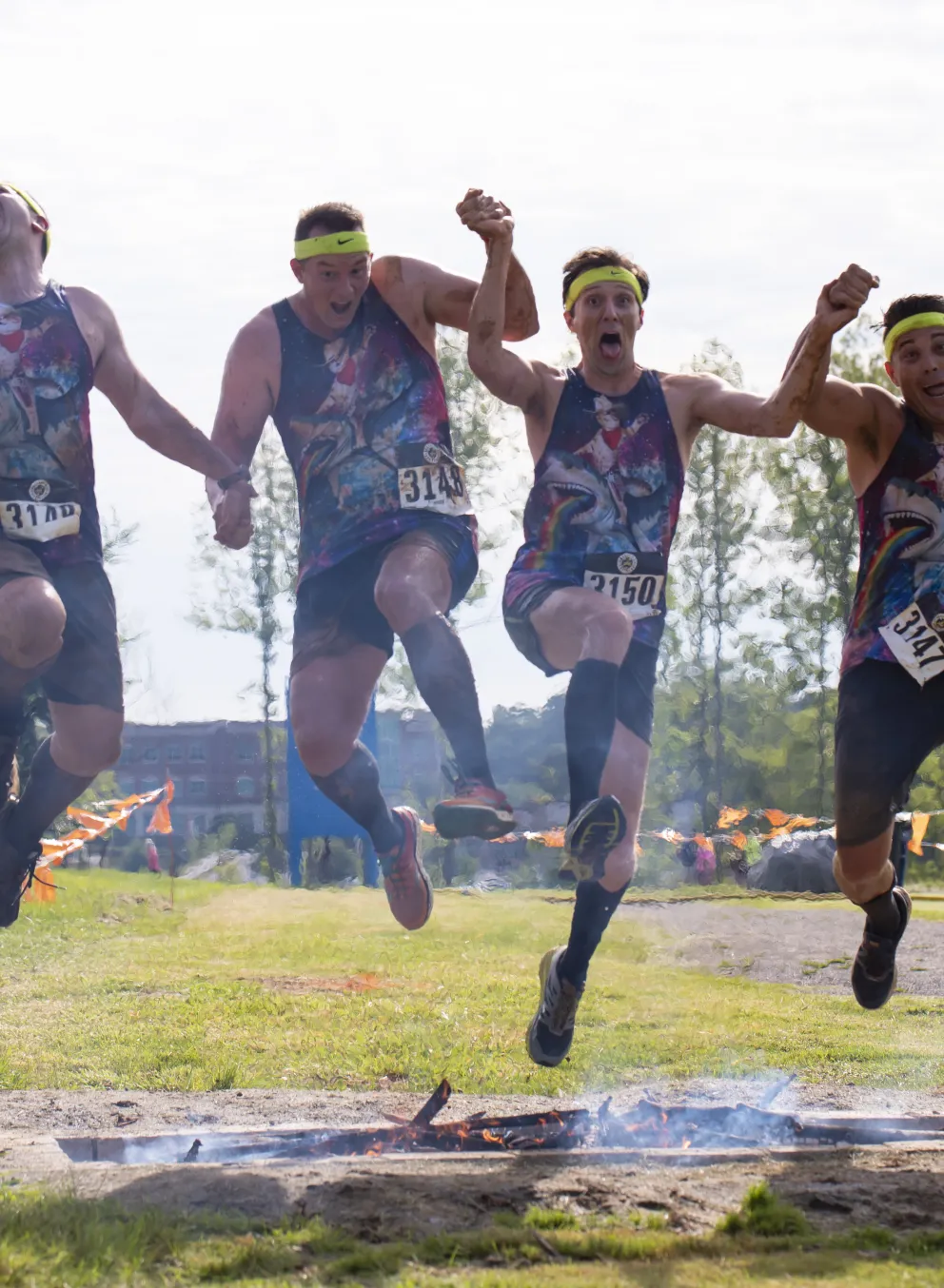 Men running the Dirty Dozen Mud Run and jumping