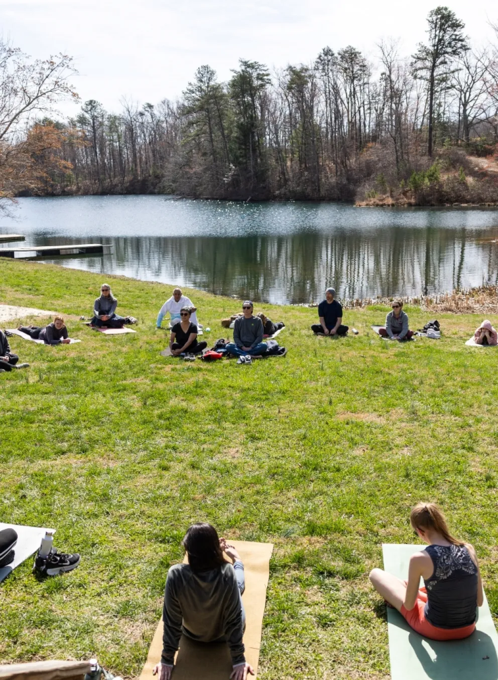 People doing yoga by a lake