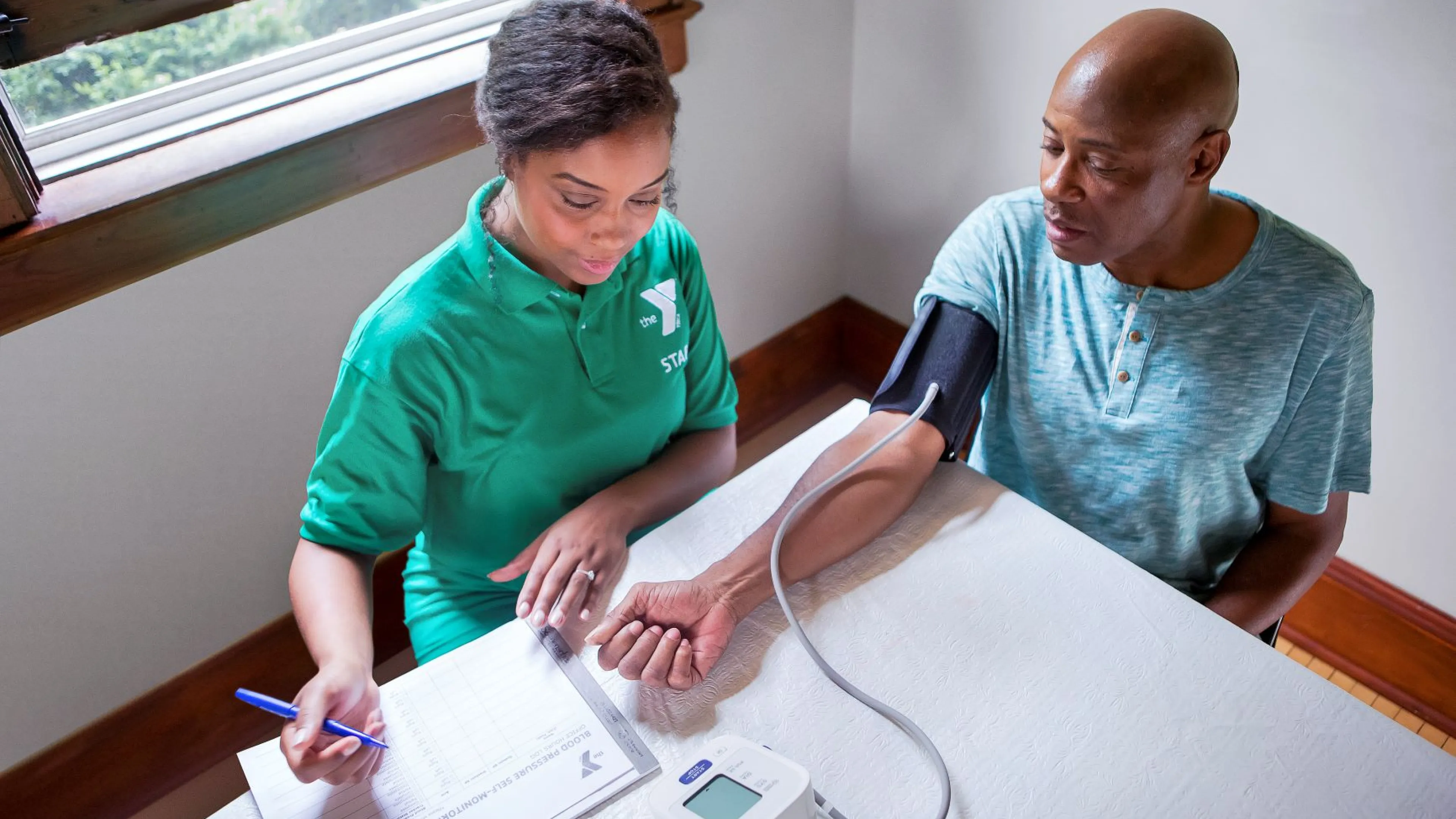 YMCA staff person taking someone's blood pressure