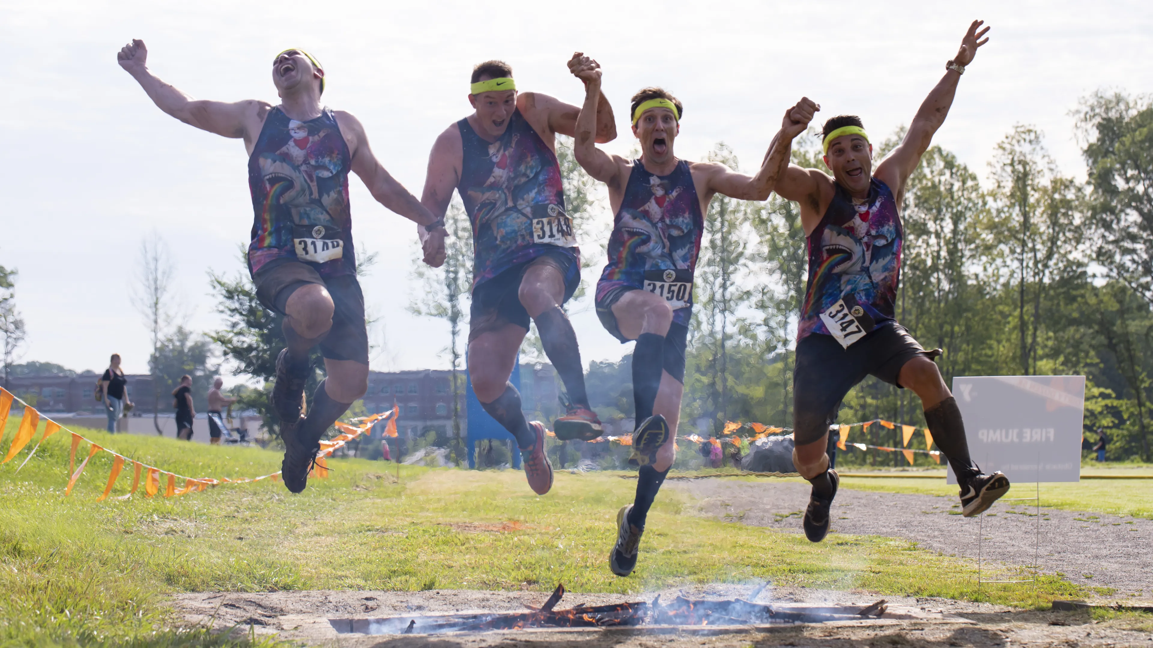 Men running the Dirty Dozen Mud Run and jumping