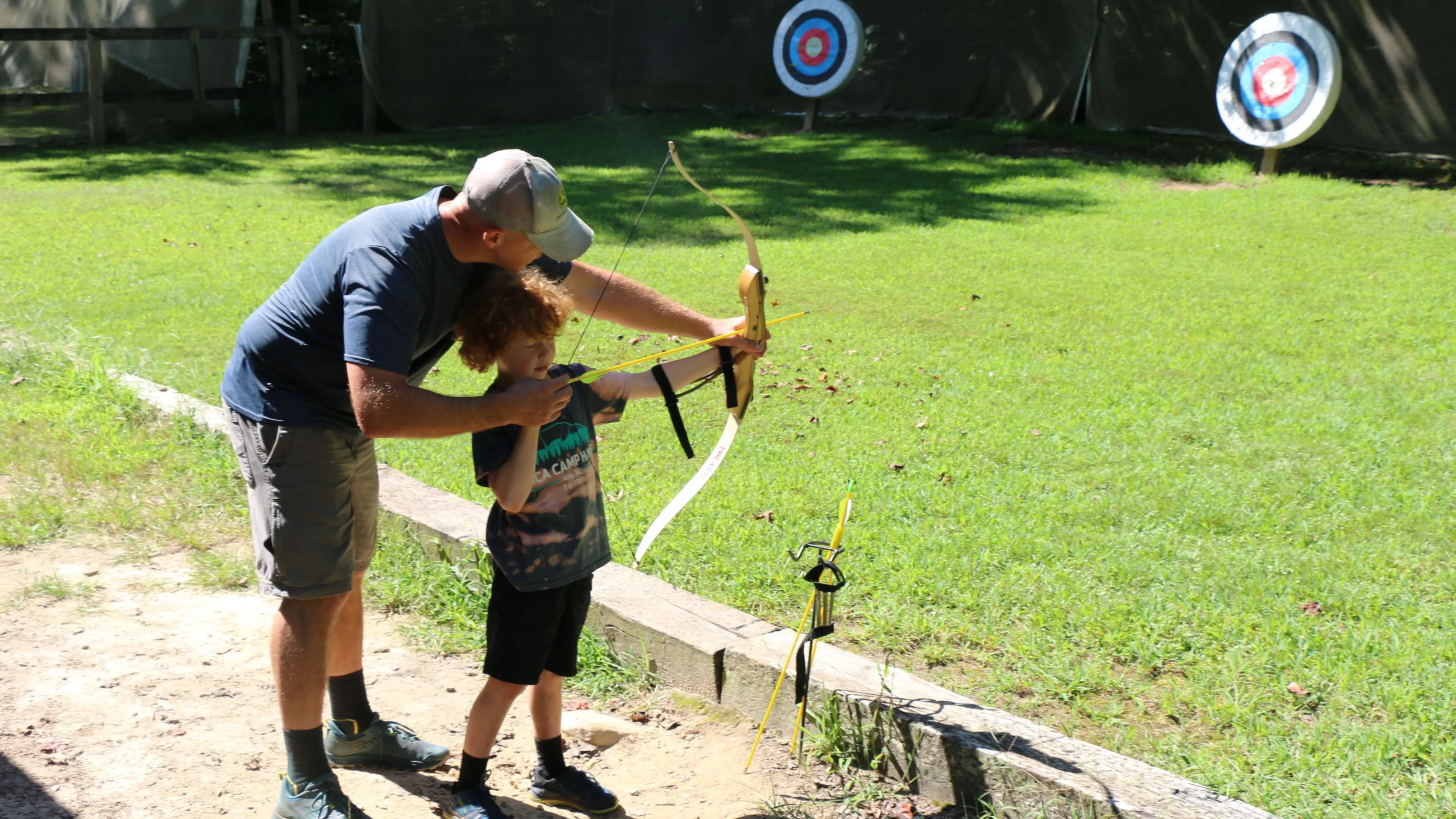 father and son shooting a bow and arrow