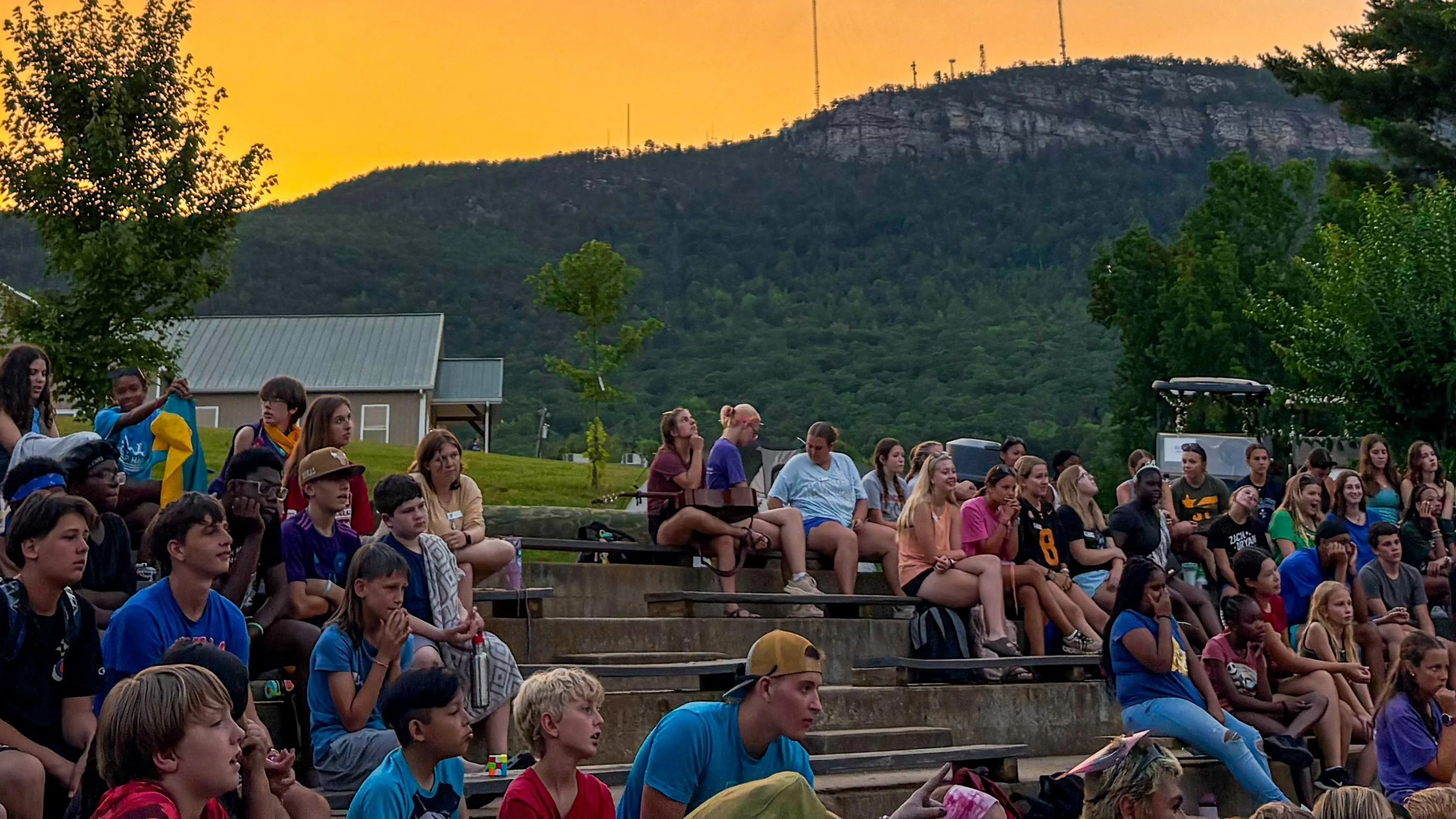 view of campers at campfire with the mountain view in the background