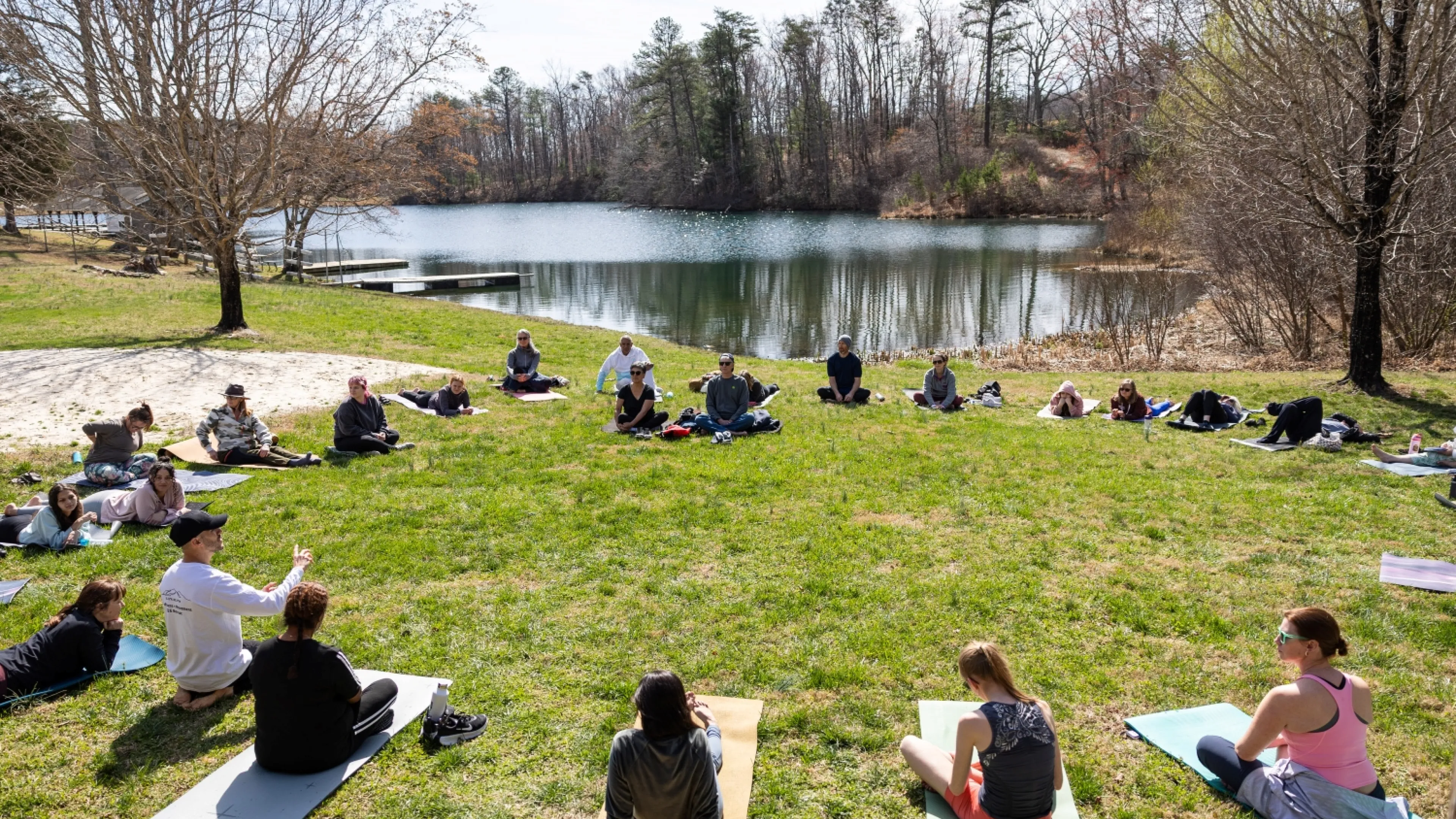 People doing yoga by a lake