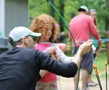 Dad and daughter doing archery