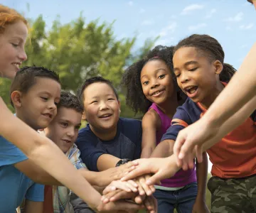 Kids all putting their hands in