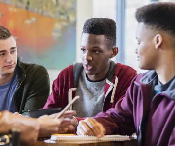 3 male teenagers studying
