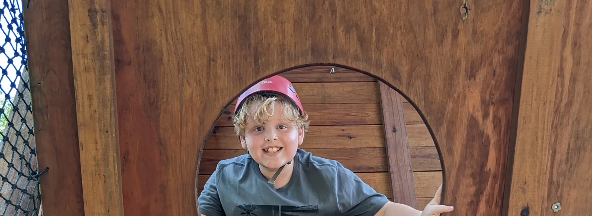 Boy in climbing wall hole