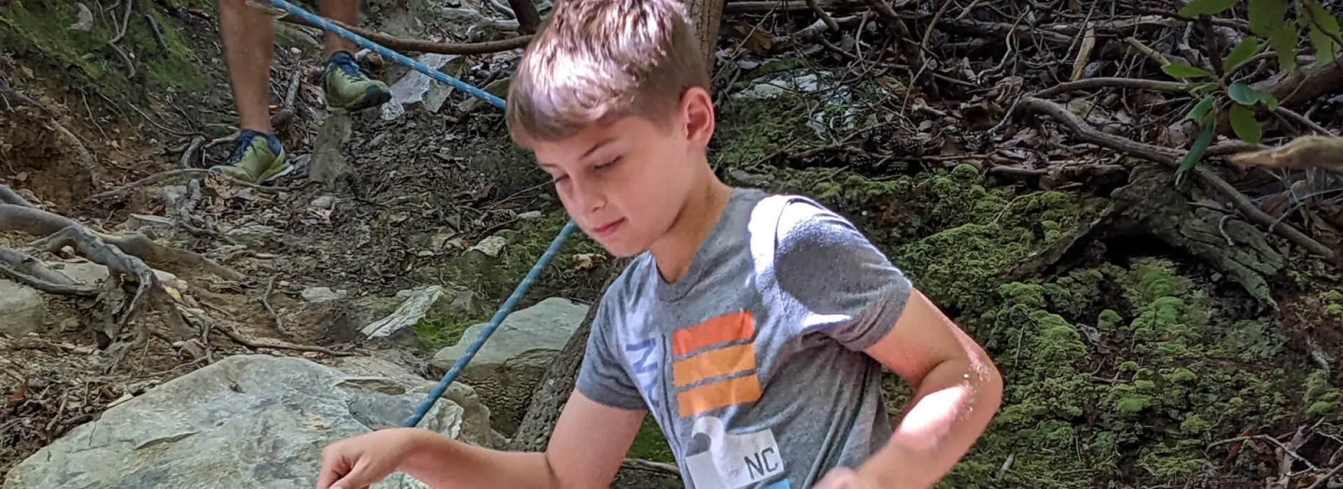 Kid climbing down hidden cliffs