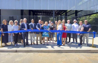 Debbie Jennings cutting ribbon infront of new airnasium