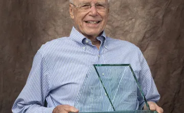 Darle Shouse holding his Red Triangle award