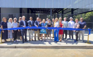 Debbie Jennings cutting ribbon infront of new airnasium